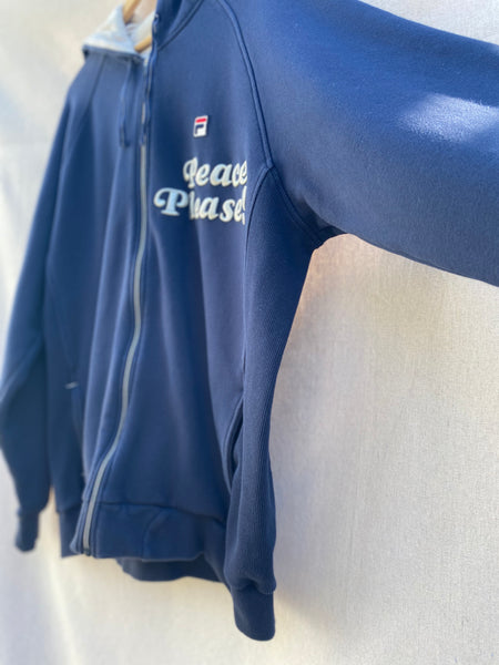 DETAILED IMAGE OF LEFT SIDE PANEL OF NAVY HOODIE.