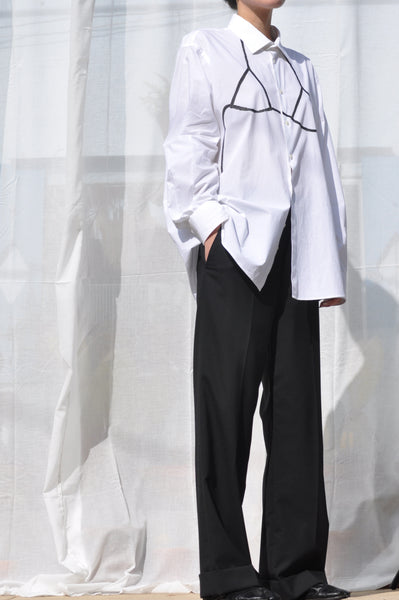 MODEL WEARING UNISEX SECONDHAND BUTTON DOWN SHIRT WITH HAND PAINTED BIKINI TOP CONTRAST IN BLACK.