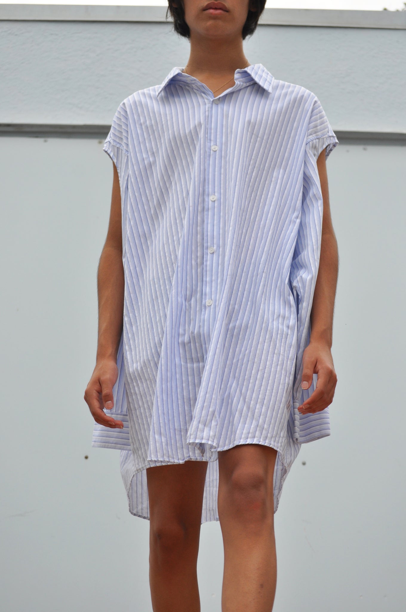 CLOSE UP VIEW OF OVERSIZED BUTTON DOWN SHIRT WITH SLEEVES CUT OUT