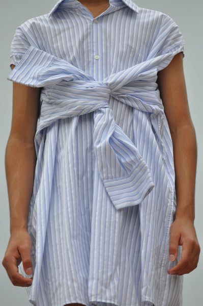 CLOSE UP VIEW OF FRONT BUTTON DOWN SHIRT WITH KNOTTED SLEEVES.