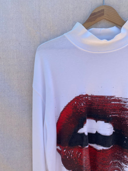CLOSE UP VIEW OF FRONT TOP RIGHT SHOULDER AND NECK. PARTIAL VIEW OF PRINTED MOUTH WITH RED LIPS.