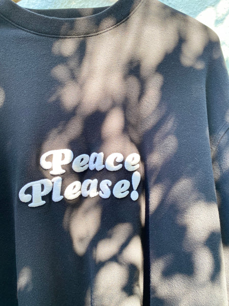 CLOSE UP IMAGE OF PEACE PLEASE EMBROIDERY IN IVORY