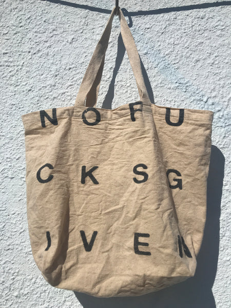 IMAGE OF TOTE BAG IN NATURAL MUSLIN COLOR. PRINT READS NOFUCKSGIVEN IN BLACK.