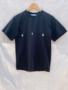 FRONT VIEW OF BLACK T-SHIRT WITH R A D EMBROIDERY ON IT.