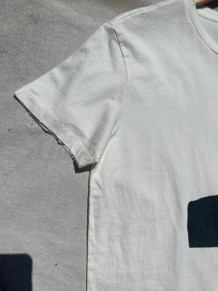 CLOSE UP IMAGE OF DISTRESS DETAILS AT SLEEVE HEM.