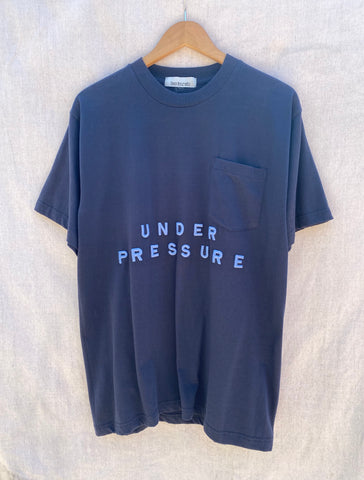 VIEW OF FRONT NAVY T-SHIRT WITH UNDER PRESSURE EMBROIDERED ON IT IN SKYBLUE THREAD.