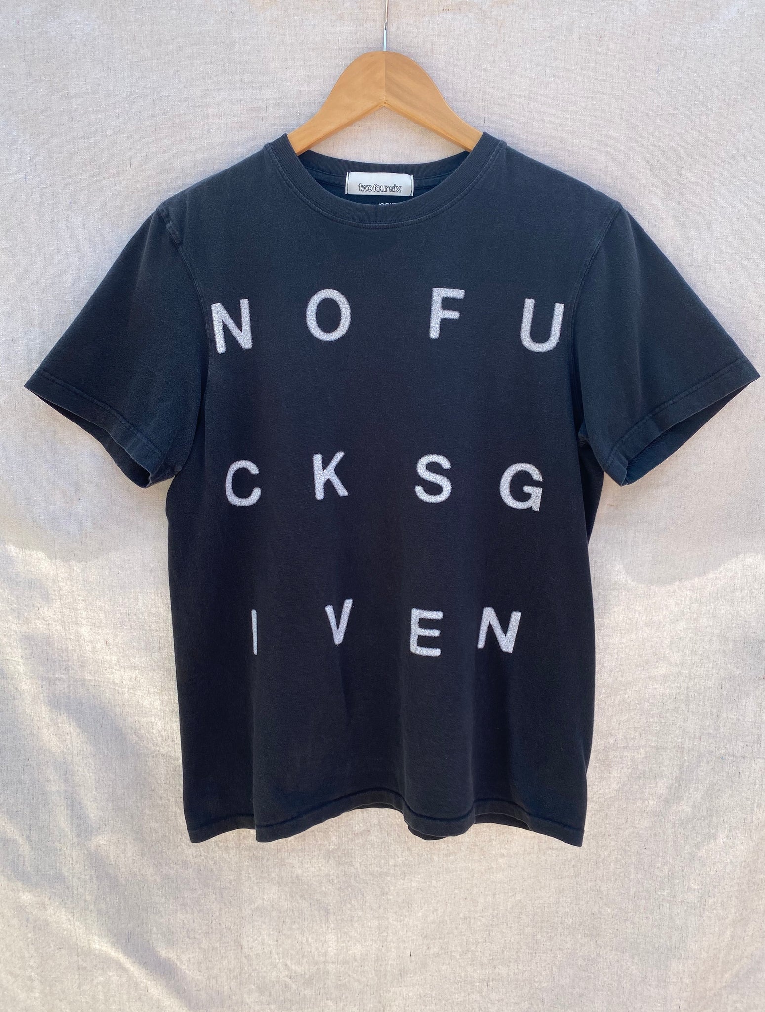 FONT VIEW FADED  BLACK T-SHIRT WITH WHITE NOFUCKSGIVEN PRINTED IN BLOCK LETTERS.