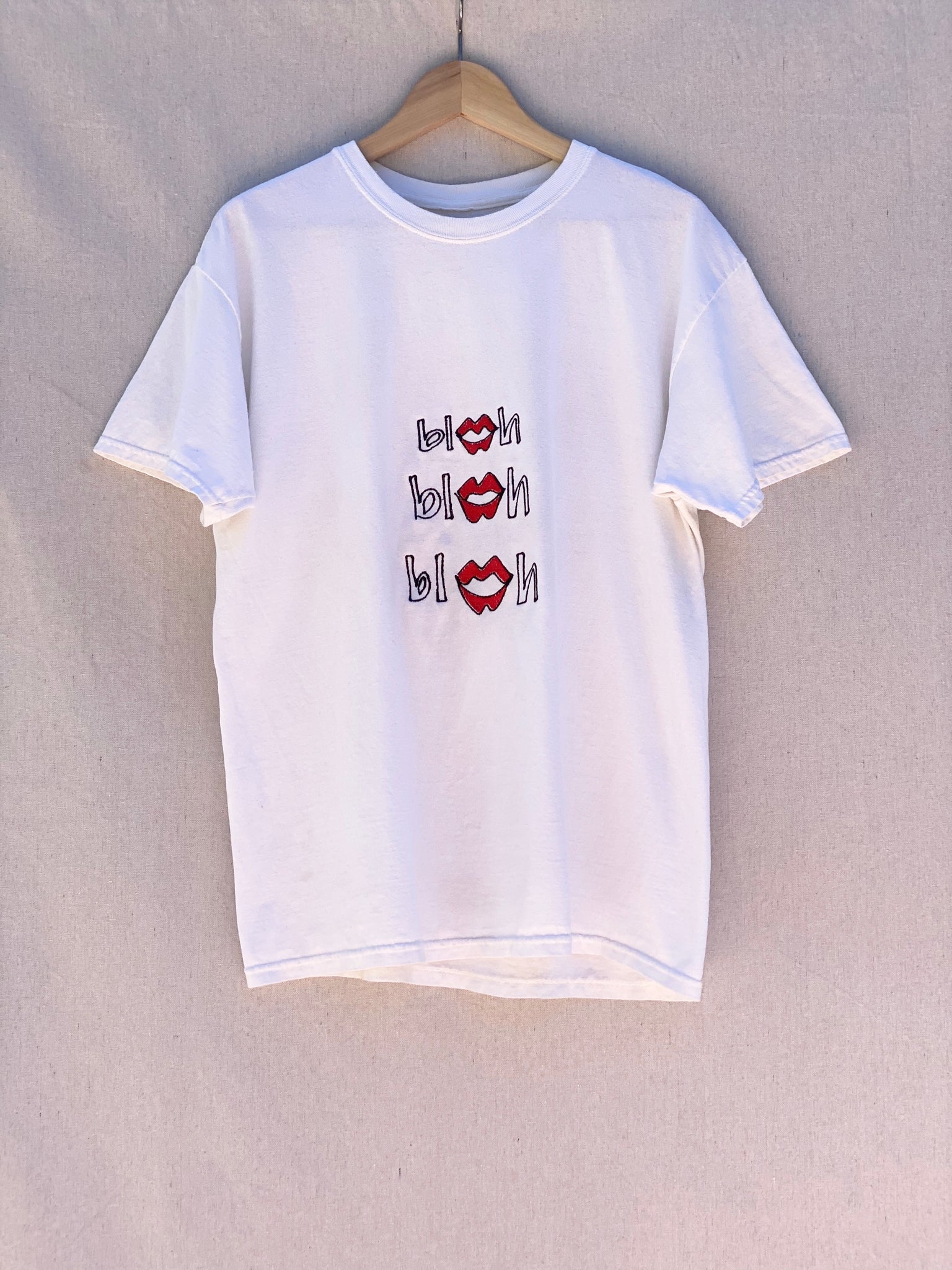 WHITE T-SHIRT WITH BLAH BLAH BLAH EMBROIDERED AT FRONT.