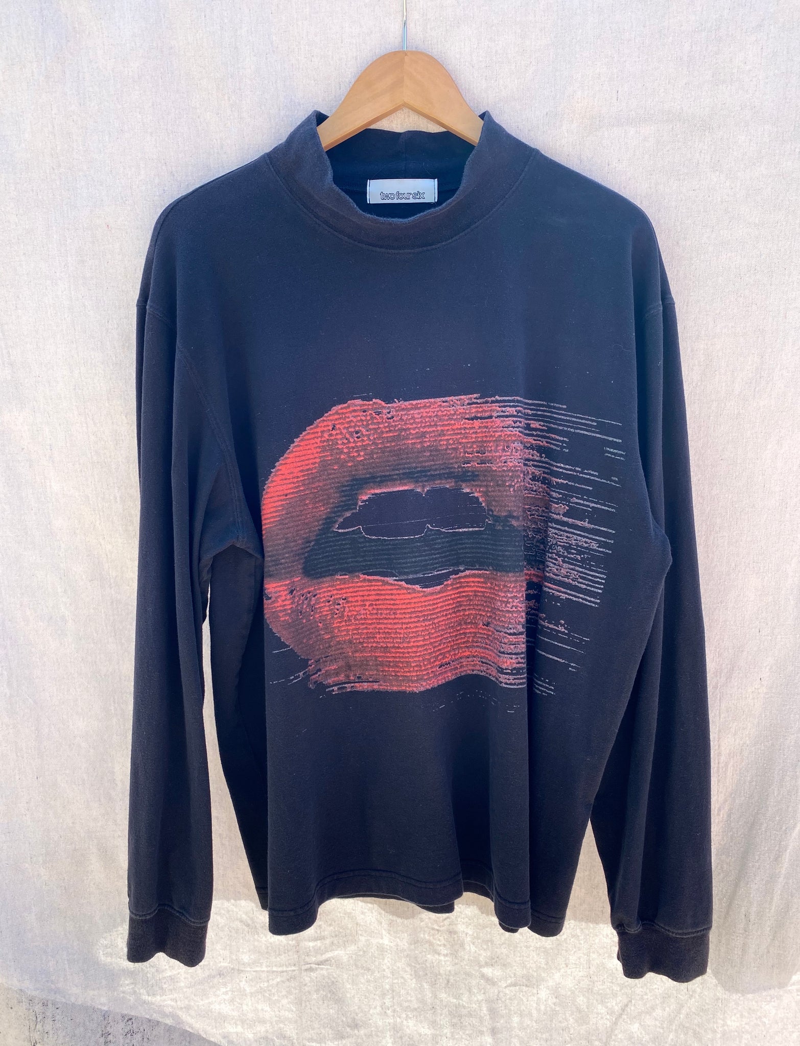 FRONT VIEW BLACK LONG SLEEVE MOCK NECK WITH RED LIPS PRINTED ON IT.